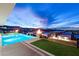 Stunning infinity pool with fire pit and city lights view at dusk at 661 Ridgestone Rim Ct, Henderson, NV 89012