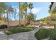 Landscaped backyard with lush lawn, palm trees, and walkway at 7501 Bachelors Button Dr, Las Vegas, NV 89131