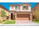 Two-story house with tan exterior, brown garage door, and landscaped front yard at 12540 Mosticone Way, Las Vegas, NV 89141