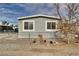 Front view of a gray manufactured home with a chain link fence at 100 Vegas Valley Dr, Pahrump, NV 89048