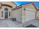 Front entry and attached two-car garage with light-colored exterior at 1009 Pueblo Hills Ave, North Las Vegas, NV 89032