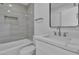 Modern bathroom with white vanity, gray tile, and bathtub at 7640 Sea Wind Dr, Las Vegas, NV 89128