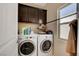 Laundry room with washer, dryer, and overhead cabinets at 9417 Sand Tiger Ave, Las Vegas, NV 89148