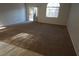 Spacious living room with neutral carpet and access to the backyard at 1509 Silver Sunset Dr, Henderson, NV 89052