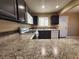 Kitchen boasts dark cabinets, white appliances, and granite countertops at 6524 Ouida Way, Las Vegas, NV 89108