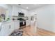 Modern kitchen with white cabinets, stainless steel appliances, and wood floors at 9621 Blue Bell Dr, Las Vegas, NV 89134