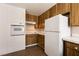 Kitchen with wood cabinets and white appliances at 136 Greenbriar Townhouse Way, Las Vegas, NV 89121