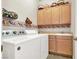 Bright laundry room with washer, dryer, cabinets, and a utility sink at 2110 Mooreview St, Henderson, NV 89012