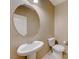 Small bathroom with pedestal sink and round mirror at 7542 Fort Mcdermitt Ave, Las Vegas, NV 89179