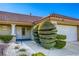 House exterior with terracotta roof, well-manicured landscaping, and a white two-car garage at 8745 Smokey Dr, Las Vegas, NV 89134