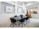 Modern dining room with black table and chairs, stylish wall decor, and large windows at 9843 High Alpine St, Las Vegas, NV 89178