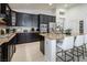 Modern kitchen with dark cabinetry, granite island and stainless steel appliances at 9843 High Alpine St, Las Vegas, NV 89178