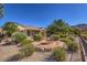 Desert landscaped backyard with a covered patio and a metal table and chairs at 2409 Anderson Park Dr, Henderson, NV 89044