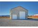 Tan colored workshop with two large garage doors at 3580 Prairie Ave, Pahrump, NV 89048