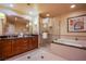 Elegant primary bathroom featuring double sinks, a glass shower, a jetted tub, and modern fixtures at 125 E Harmon Ave # 2801 & 2803, Las Vegas, NV 89109