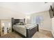 Main bedroom with large bed, mirror, and wall-mounted TV at 2135 Prevail Dr, North Las Vegas, NV 89032