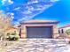 Front view of a tan house with a gray garage door at 4036 Shetland Pony St, Las Vegas, NV 89122