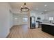 Open concept kitchen with island, stainless steel appliances, and light wood flooring at 5610 Surrey St, Las Vegas, NV 89119