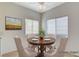 Virtually staged dining room with a round wooden table and four beige chairs at 8501 W University Ave # 2012, Las Vegas, NV 89147