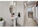 Powder room with a pedestal sink, round mirror, and modern fixtures at 9872 Russian Hill St, Las Vegas, NV 89141