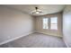 Bedroom featuring grey carpet, ceiling fan, and two windows at 10669 Aphrodite St, Las Vegas, NV 89183