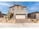 Two-story house with a beige exterior, stone accents, and a two-car garage at 230 Palisade Falls Ave, Henderson, NV 89015