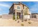 Two-story house with beige exterior, stone accents, and a landscaped front yard at 230 Palisade Falls Ave, Henderson, NV 89015