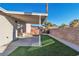 Covered patio and grassy backyard with block wall at 5963 Natures Dr, Las Vegas, NV 89122