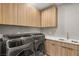 Modern laundry room with front-load washer and dryer, and ample counter space at 12 Falling Canyon Ct, Henderson, NV 89011