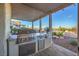 Outdoor kitchen with built-in grill, stone countertops, and stunning views at 2124 Sierra Heights Dr, Las Vegas, NV 89134