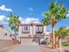 Two-story house with beige and brown exterior, two-car garage, and palm trees at 9316 Perennial Ave, Las Vegas, NV 89148