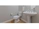 Clean bathroom with pedestal sink, toilet, and tiled floor at 12253 Bluebird Canyon Pl, Las Vegas, NV 89138