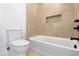 Simple bathroom with a bathtub, toilet and neutral tile at 1391 Quiet River Ave, Henderson, NV 89012