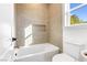 Modern bathroom with a bathtub, toilet and neutral tile at 1391 Quiet River Ave, Henderson, NV 89012