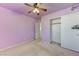 Purple bedroom with ceiling fan, open closet, and adjacent room access at 153 Sitka Spruce St, Henderson, NV 89015