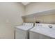 Laundry room with washer, dryer, and overhead shelving at 153 Sitka Spruce St, Henderson, NV 89015