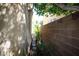 Narrow side yard with a brick wall and small plants at 6437 Boatbill St, North Las Vegas, NV 89084