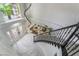 Elegant curved staircase with black metal railing and marble flooring at 10965 Inverlochy Ct, Las Vegas, NV 89141