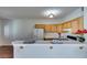 Kitchen boasts wood cabinets, white appliances, and a breakfast bar at 2110 Los Feliz St # 1097, Las Vegas, NV 89156