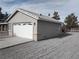 Attached two-car garage with white doors and gravel driveway at 410 E Gamebird Rd, Pahrump, NV 89048