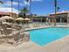 Community pool with lounge chairs and rock waterfall feature at 5427 Indian River Dr # 418, Las Vegas, NV 89103