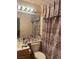 Bathroom boasts a toilet, vanity, and shower with patterned curtains at 716 Solitude Point Ave, Henderson, NV 89012