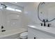 Modern bathroom with white vanity, black matte fixtures, and bathtub at 8412 Wildheart Ranch St, Las Vegas, NV 89131