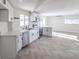 Open concept kitchen with white cabinets, stainless steel appliances, and herringbone floors at 103 Magnesium St, Henderson, NV 89015