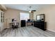 Bright bedroom featuring a home office setup and wood-look flooring at 6250 Buffalo Spring Ct, Las Vegas, NV 89122