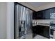 Stainless steel refrigerator in a modern kitchen with dark cabinetry at 6250 Buffalo Spring Ct, Las Vegas, NV 89122