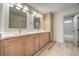 Bathroom with dual sinks, light wood cabinets, and a large mirror at 157 Tyler Ct, Henderson, NV 89074