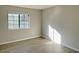 Bright bedroom with large window and wood-look floors at 7054 Burcot Ave # J43, Las Vegas, NV 89156