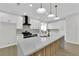 Modern kitchen with white cabinets, marble countertops, and a wood-paneled island at 1987 High Mesa Dr, Henderson, NV 89012