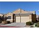 Tan house with a two-car garage and nicely landscaped front yard at 304 Whitney Breeze Ave, North Las Vegas, NV 89031